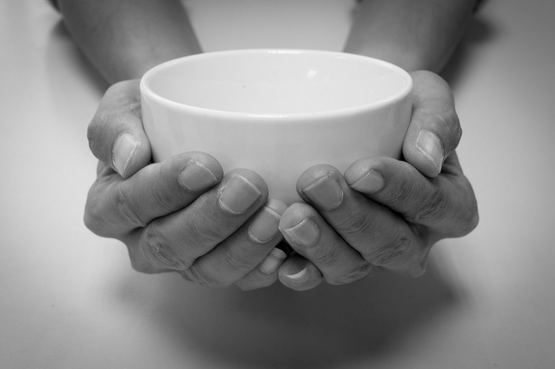 Manos sosteniendo un cuenco vacío como símbolo de pausa y consciencia al comer despacio